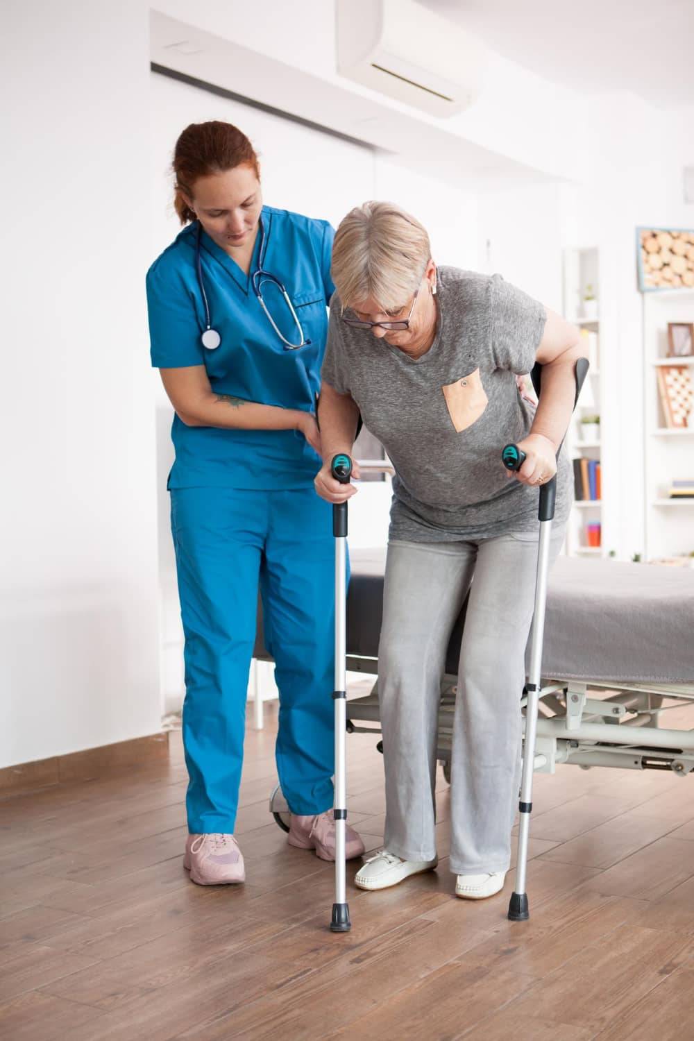 old-woman-nursing-home-walking-with-crutches-with-help-from-female-nurse